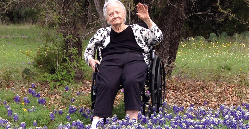 resident sitting in the wildflowers at riva ridge memory center